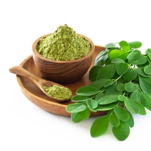 Moringa powder (Moringa Oleifera) in wooden bowl with original fresh Moringa leaves isolated on white background. Healthy product, superfood, vitamin.